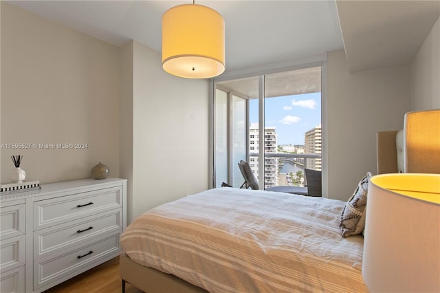 bedroom with a water view and light hardwood / wood-style floors