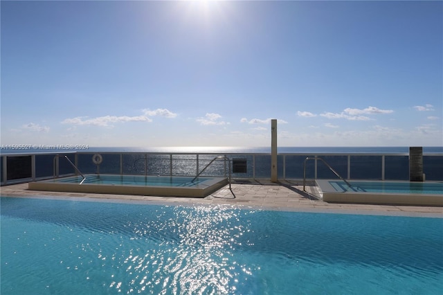 view of swimming pool featuring a water view