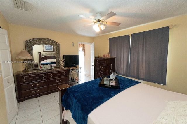 tiled bedroom with a textured ceiling and ceiling fan