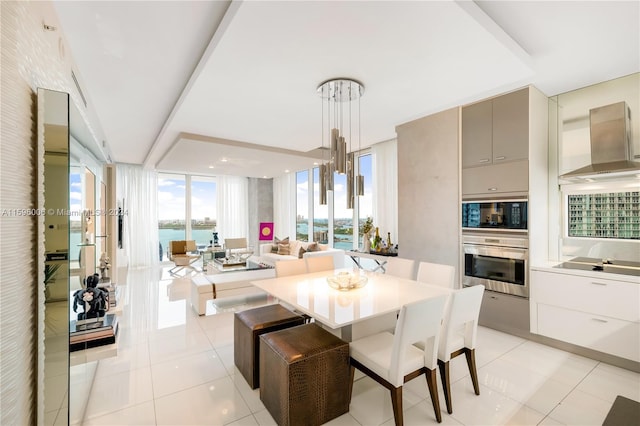 tiled dining space featuring floor to ceiling windows and a water view