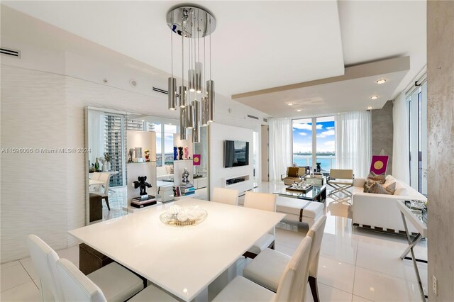 tiled dining area featuring a wall of windows and a water view