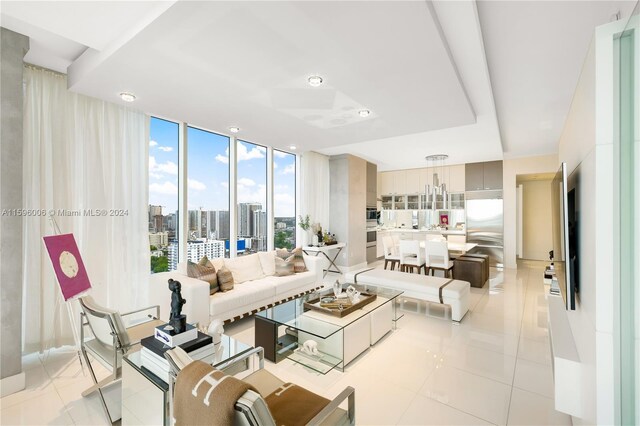 tiled living room featuring floor to ceiling windows