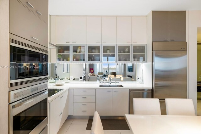 kitchen featuring black appliances, sink, and light tile floors