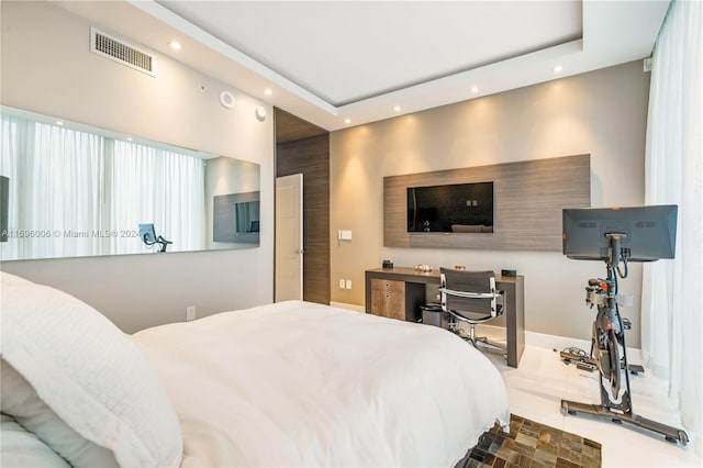 bedroom featuring dark tile flooring and a tray ceiling