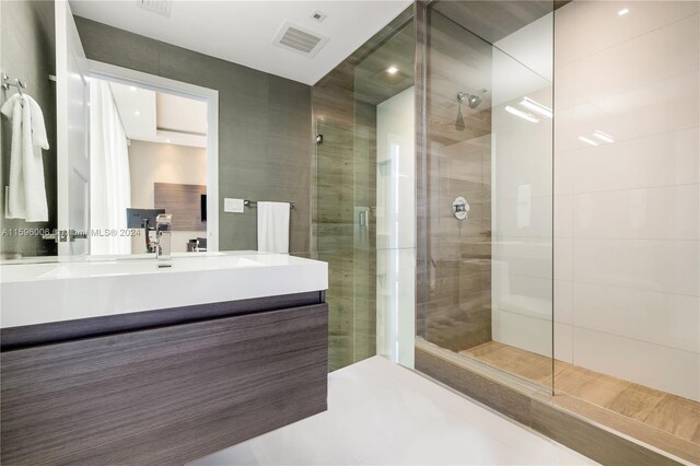 bathroom featuring tile floors, a shower with door, and vanity