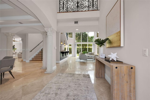 foyer entrance featuring ceiling fan and decorative columns