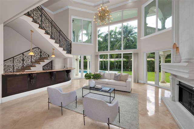 living room with ornamental molding, a high ceiling, an inviting chandelier, and french doors