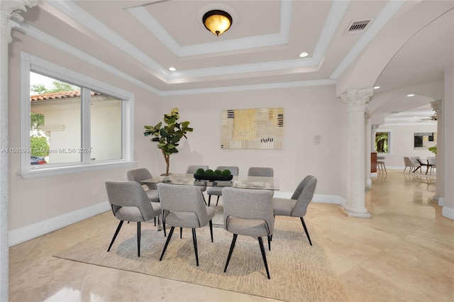 dining area with ceiling fan, ornamental molding, a tray ceiling, and decorative columns