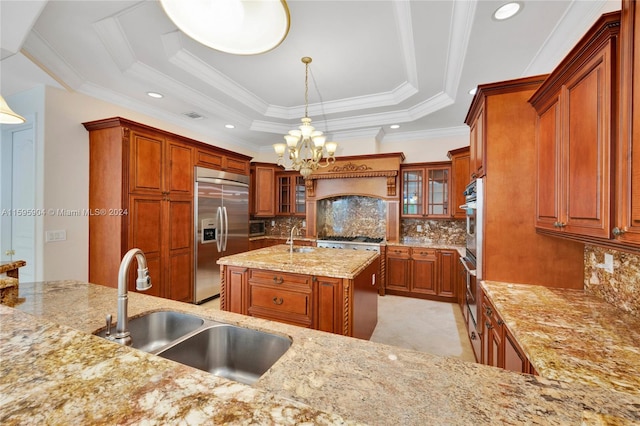 kitchen with decorative light fixtures, stainless steel appliances, sink, decorative backsplash, and a tray ceiling