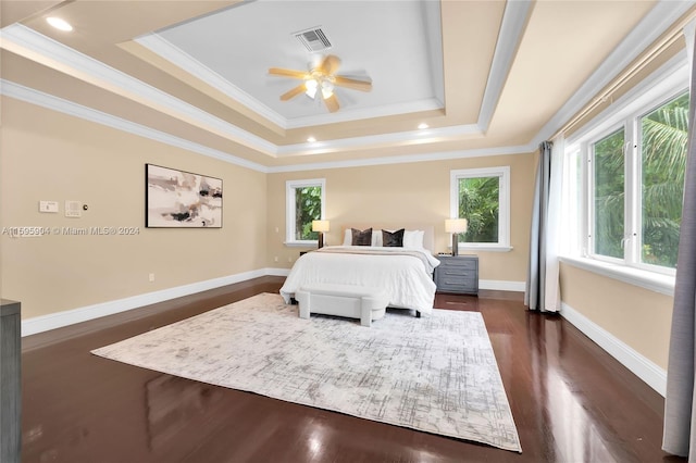 bedroom featuring crown molding, a raised ceiling, dark hardwood / wood-style flooring, and ceiling fan