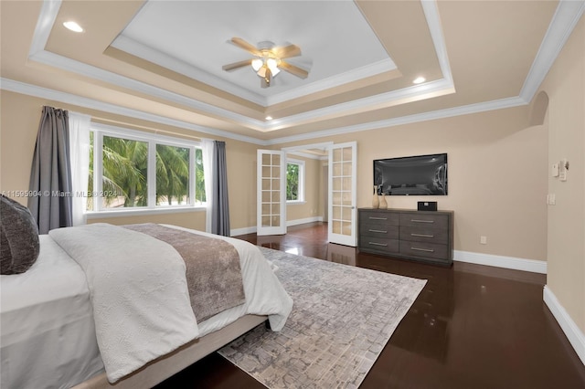 bedroom with ornamental molding, dark wood-type flooring, a raised ceiling, and ceiling fan