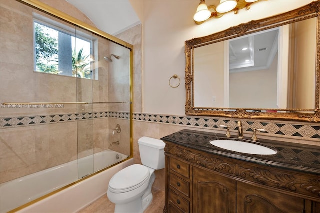 full bathroom featuring vanity, combined bath / shower with glass door, tasteful backsplash, tile walls, and toilet