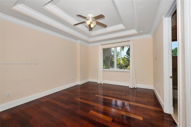 spare room with crown molding, ceiling fan, dark hardwood / wood-style floors, and a tray ceiling