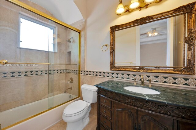 full bathroom featuring backsplash, toilet, shower / bath combination with glass door, ceiling fan, and vanity