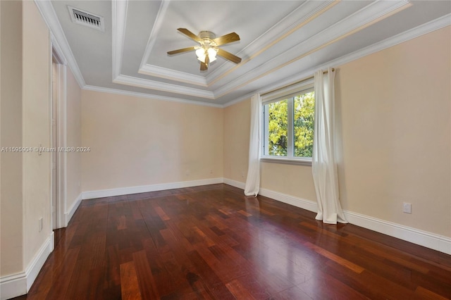 unfurnished room with ornamental molding, dark hardwood / wood-style flooring, a tray ceiling, and ceiling fan