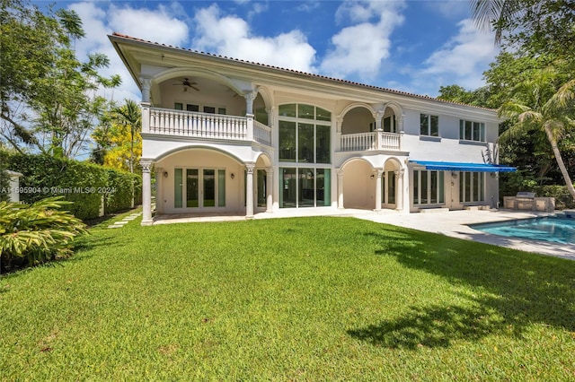 back of property featuring a balcony, a yard, and a patio area