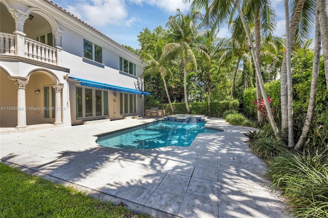 view of pool featuring a patio area and an in ground hot tub