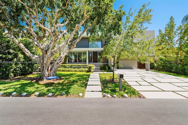 view of property hidden behind natural elements with a garage