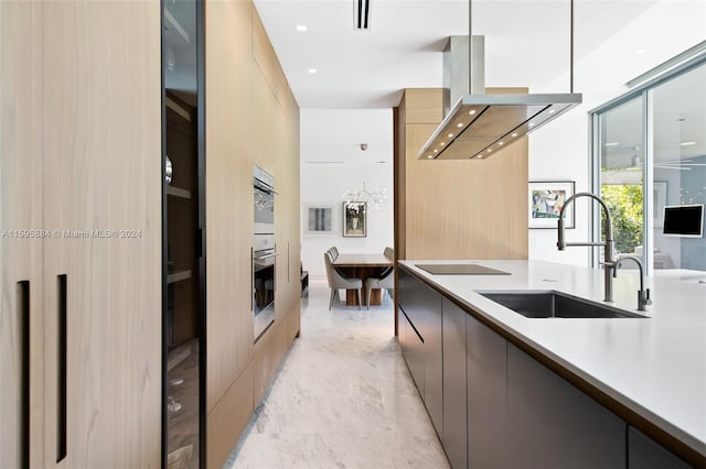 kitchen with island exhaust hood, black electric stovetop, decorative light fixtures, and sink