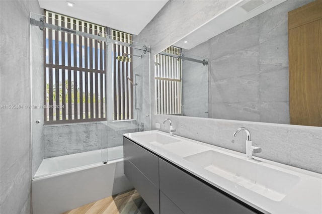 bathroom with vanity, tile walls, and enclosed tub / shower combo