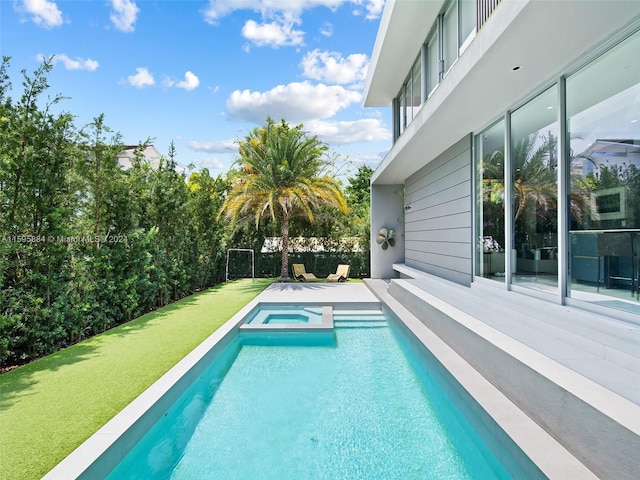 view of pool with an in ground hot tub and a yard