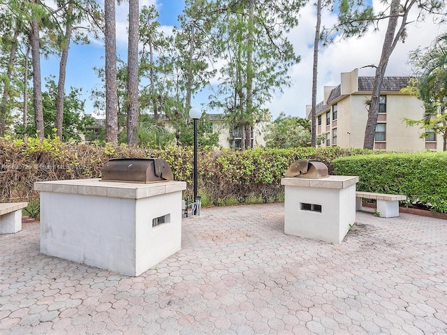 view of patio featuring exterior kitchen and a grill