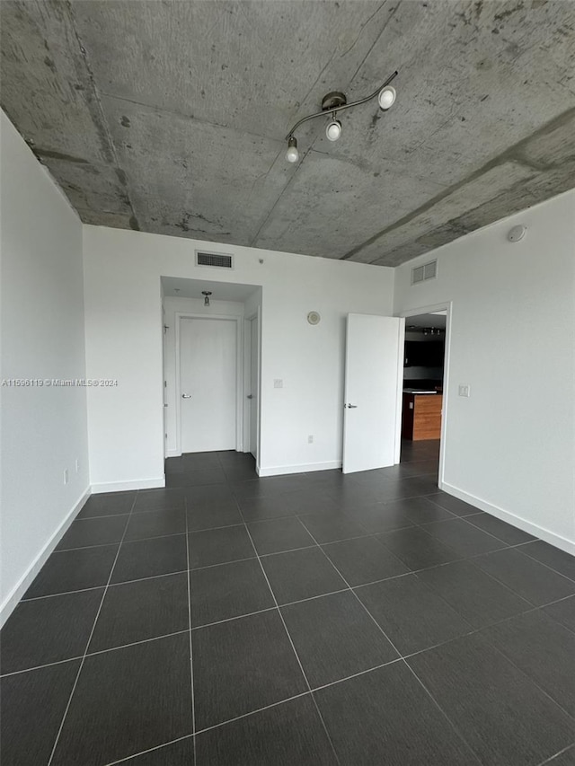 unfurnished room with dark tile patterned floors