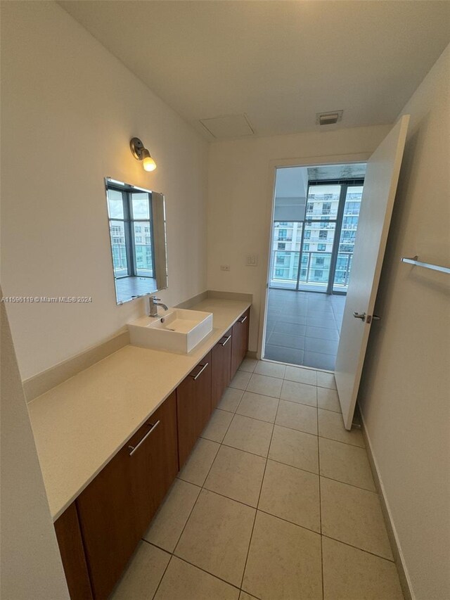 bathroom featuring tile patterned flooring, a healthy amount of sunlight, and vanity