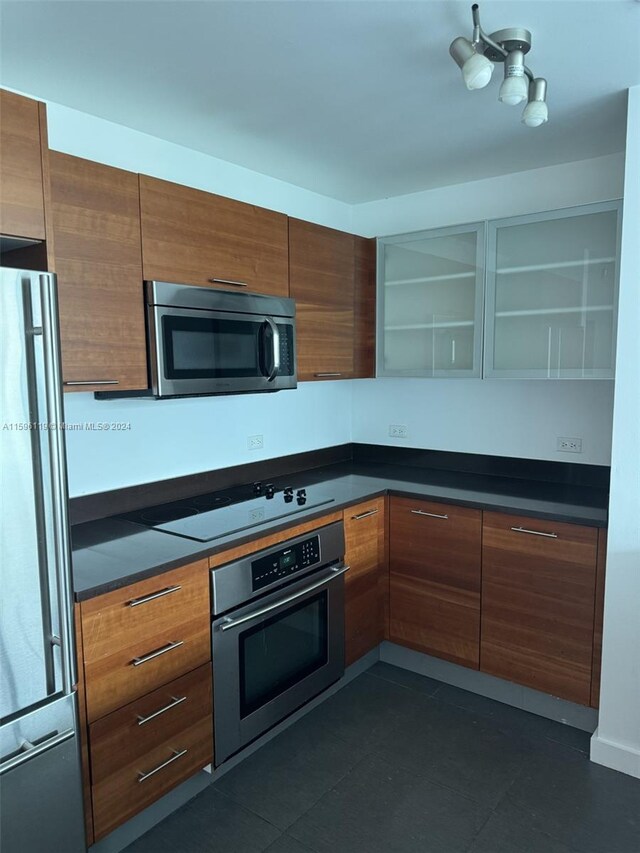 kitchen featuring dark tile patterned floors and stainless steel appliances