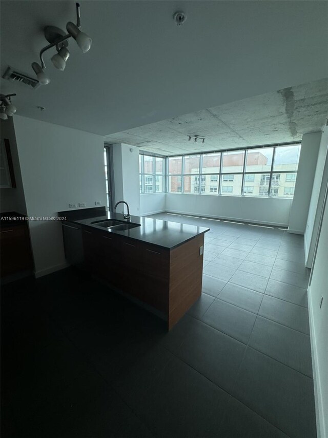 kitchen with light tile patterned floors, a center island, and sink