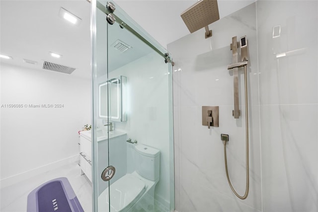 bathroom featuring vanity, an enclosed shower, and toilet