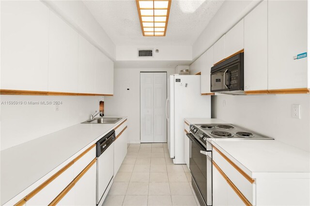 kitchen featuring white dishwasher, white cabinets, electric stove, sink, and light tile floors