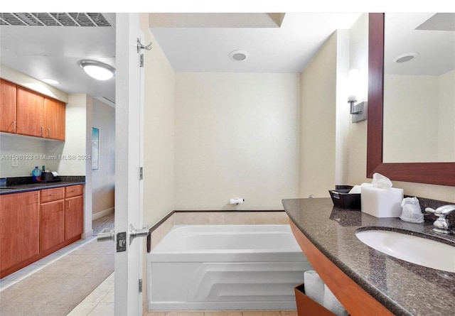 bathroom featuring tile flooring, a bathing tub, and vanity