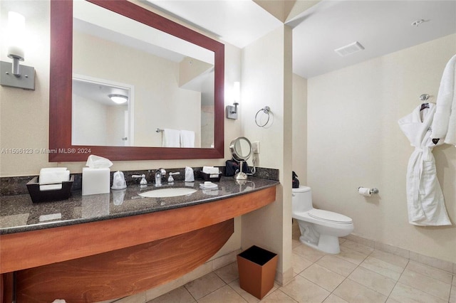 bathroom featuring tile flooring, toilet, and vanity with extensive cabinet space