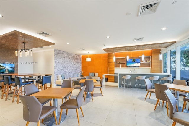 tiled dining space featuring wooden walls