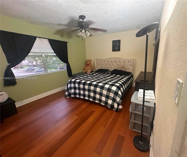 bedroom with baseboards, a textured ceiling, wood finished floors, and a ceiling fan