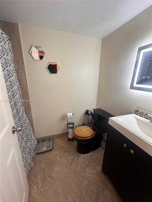 full bathroom with vanity, a shower with curtain, a textured ceiling, toilet, and a textured wall