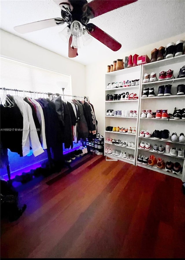 walk in closet with wood finished floors and a ceiling fan