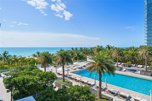 view of pool featuring a water view and a patio area