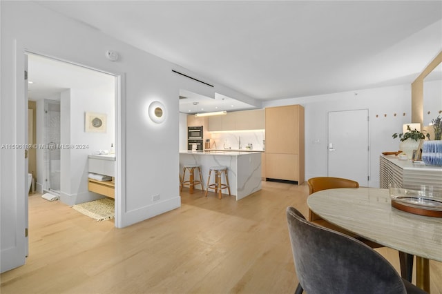 dining room with light wood-type flooring and baseboards