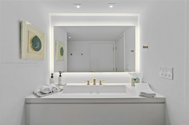 bathroom featuring recessed lighting and a sink