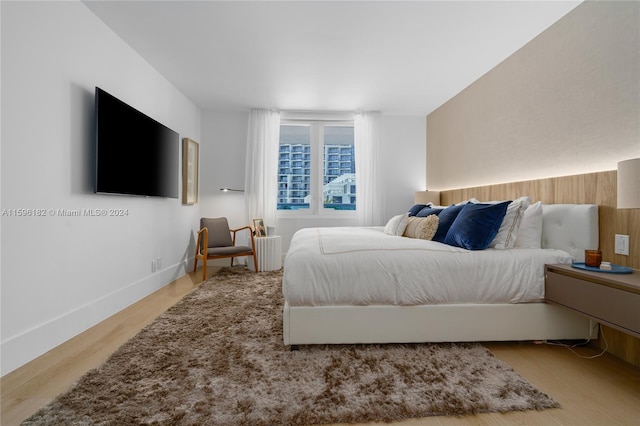 bedroom with light wood-style flooring and baseboards