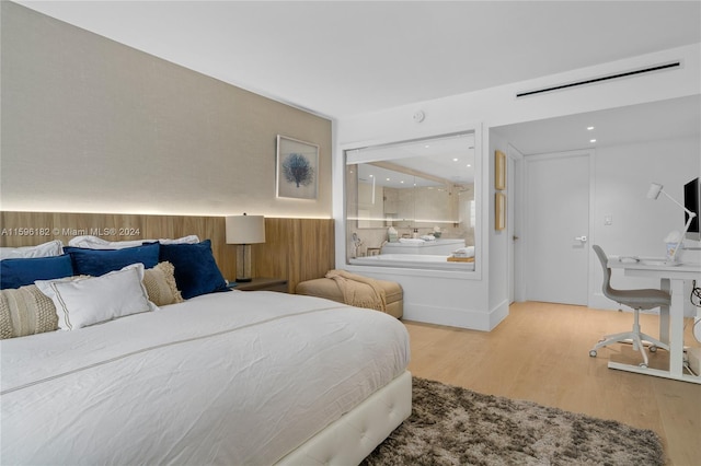 bedroom with a wainscoted wall and wood finished floors