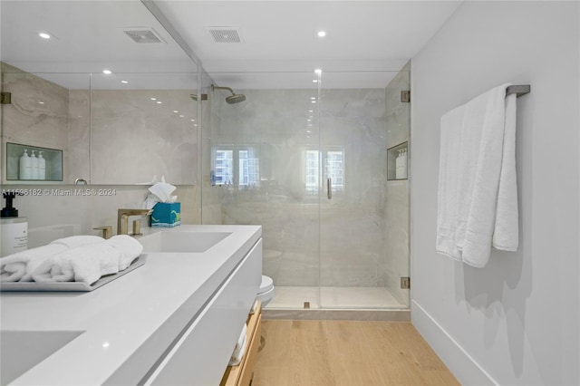 bathroom featuring a marble finish shower, wood finished floors, and visible vents