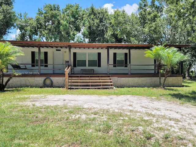 exterior space with ceiling fan and a front lawn