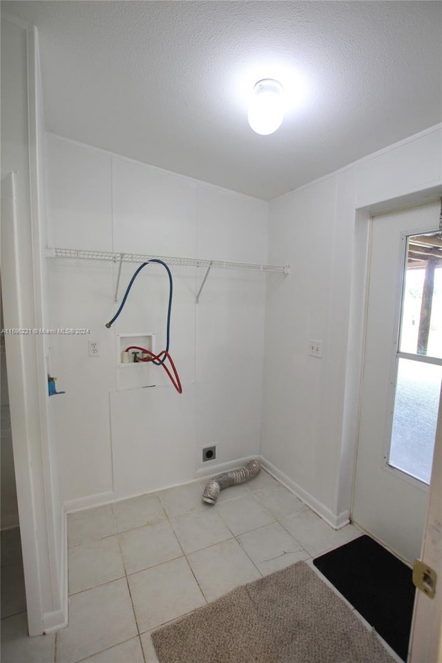 laundry area featuring washer hookup, light tile patterned floors, hookup for an electric dryer, and a textured ceiling