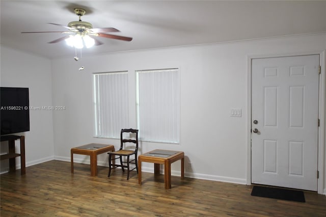 sitting room featuring ornamental molding, dark wood-type flooring, and ceiling fan