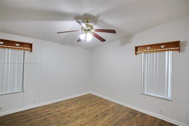 empty room with ceiling fan and dark hardwood / wood-style flooring