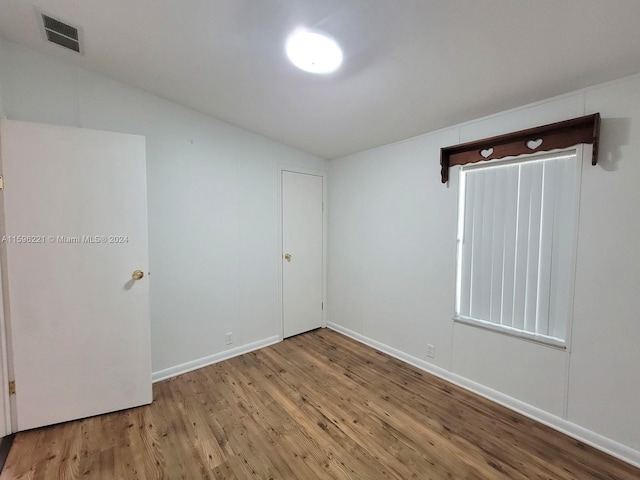 unfurnished room with lofted ceiling and light hardwood / wood-style flooring