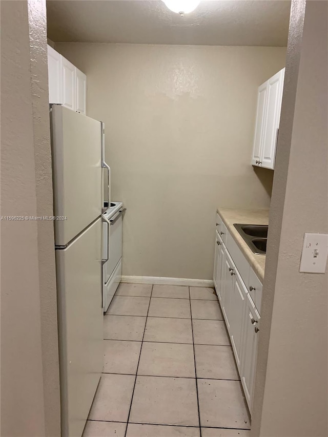 kitchen featuring white cabinetry, sink, light tile patterned floors, and white appliances